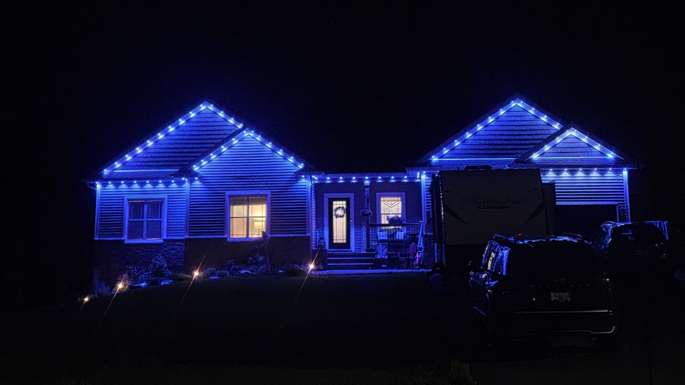 A bungalow outlined in blue GOVEE permanent lights at night