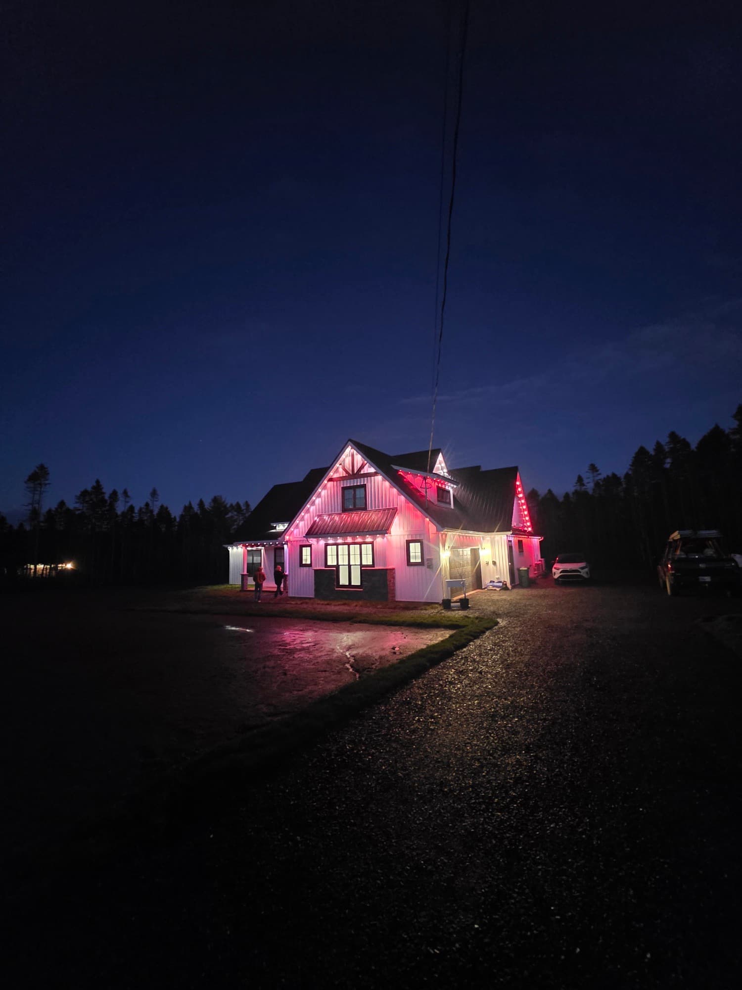 Farmhouse lit in red and white at dusk